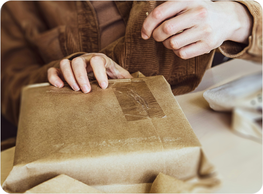 Carefully wrapping a parcel for shipment